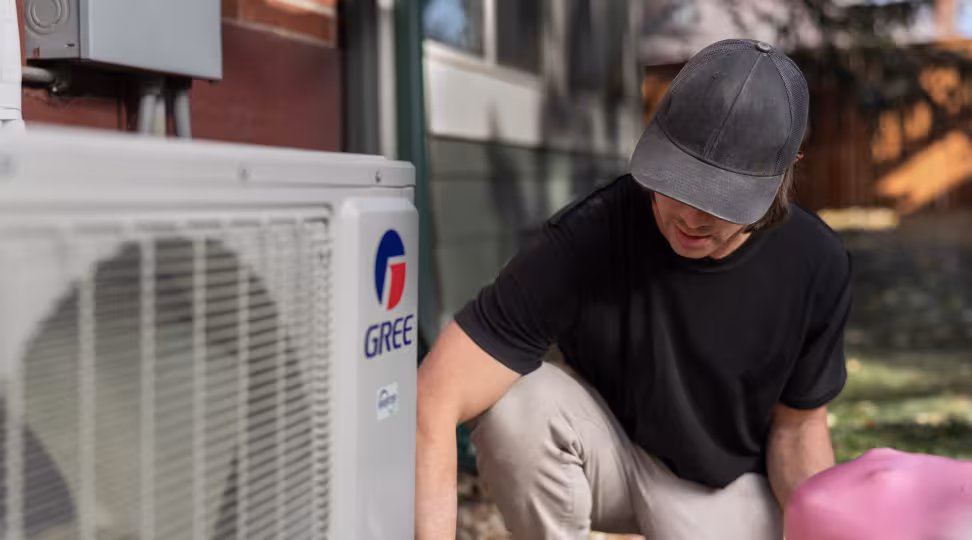 A closeup of a HVAC worker fixing a heat pump